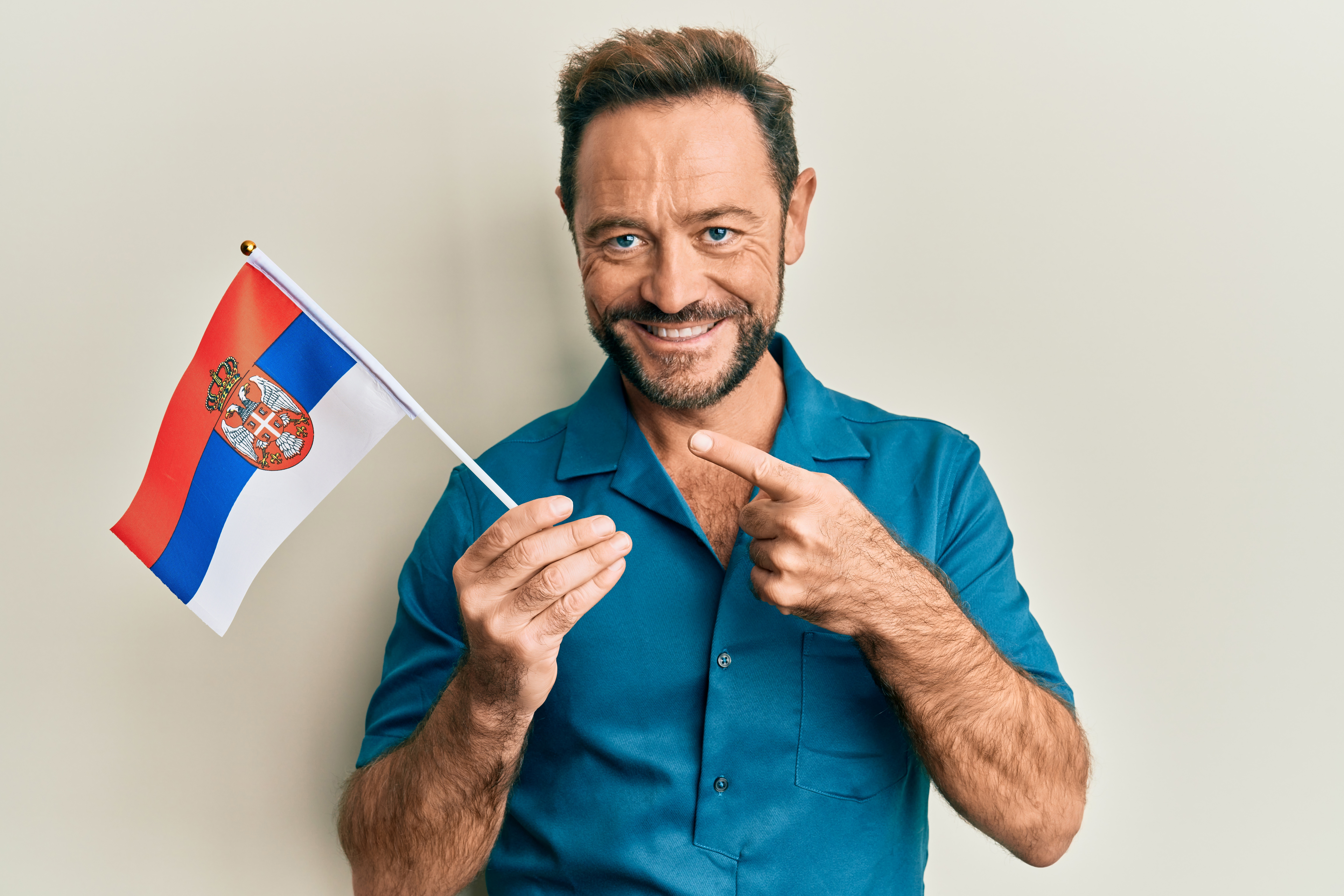 Мужчина с флагом Сербии, где он может оформить гражданство