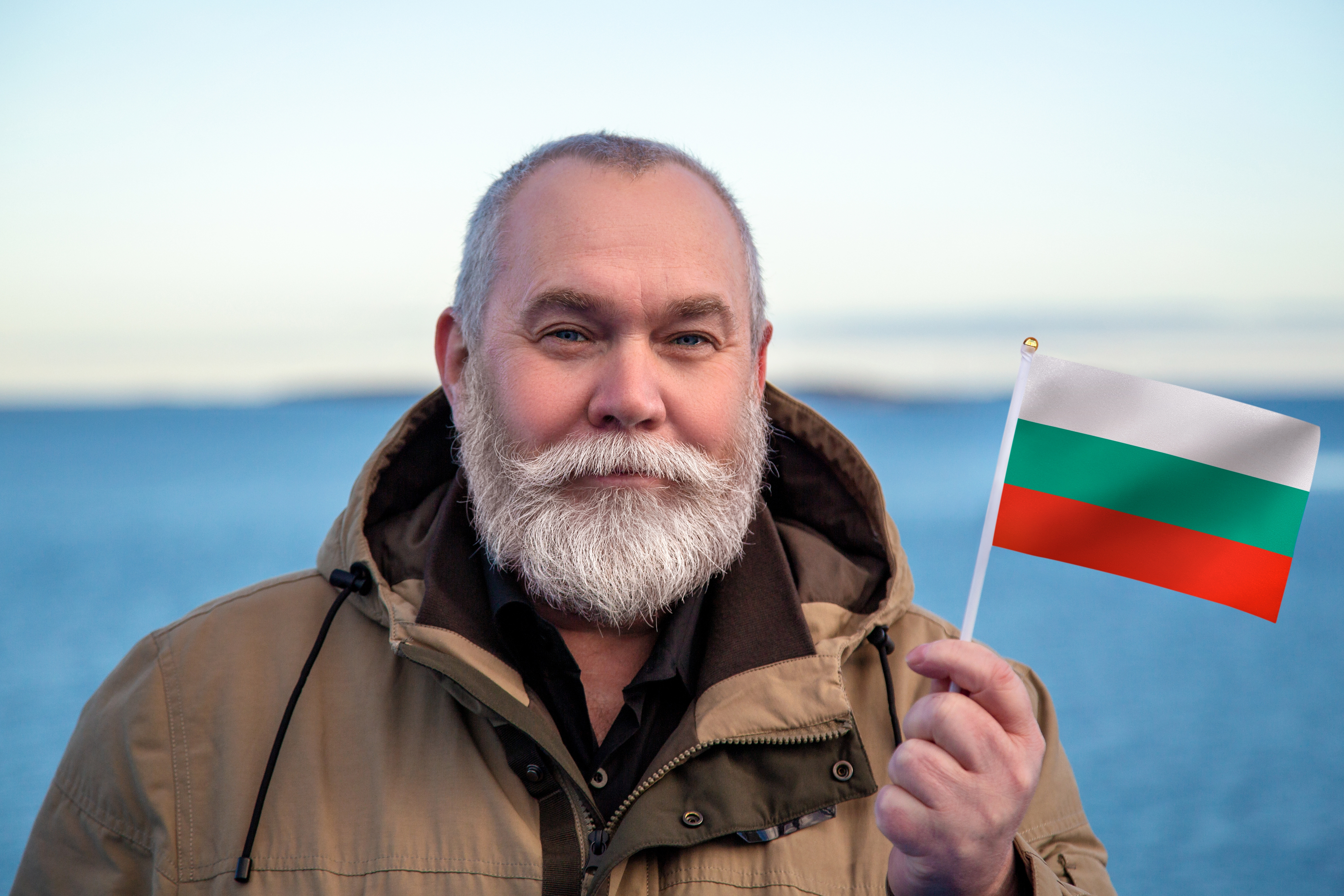 Мужчина с флагом Болгарии, где он получил гражданство по происхождению